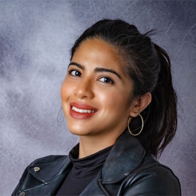 Kristina's headshot against a gray painted studio background for Kristina Yazmin Photography.